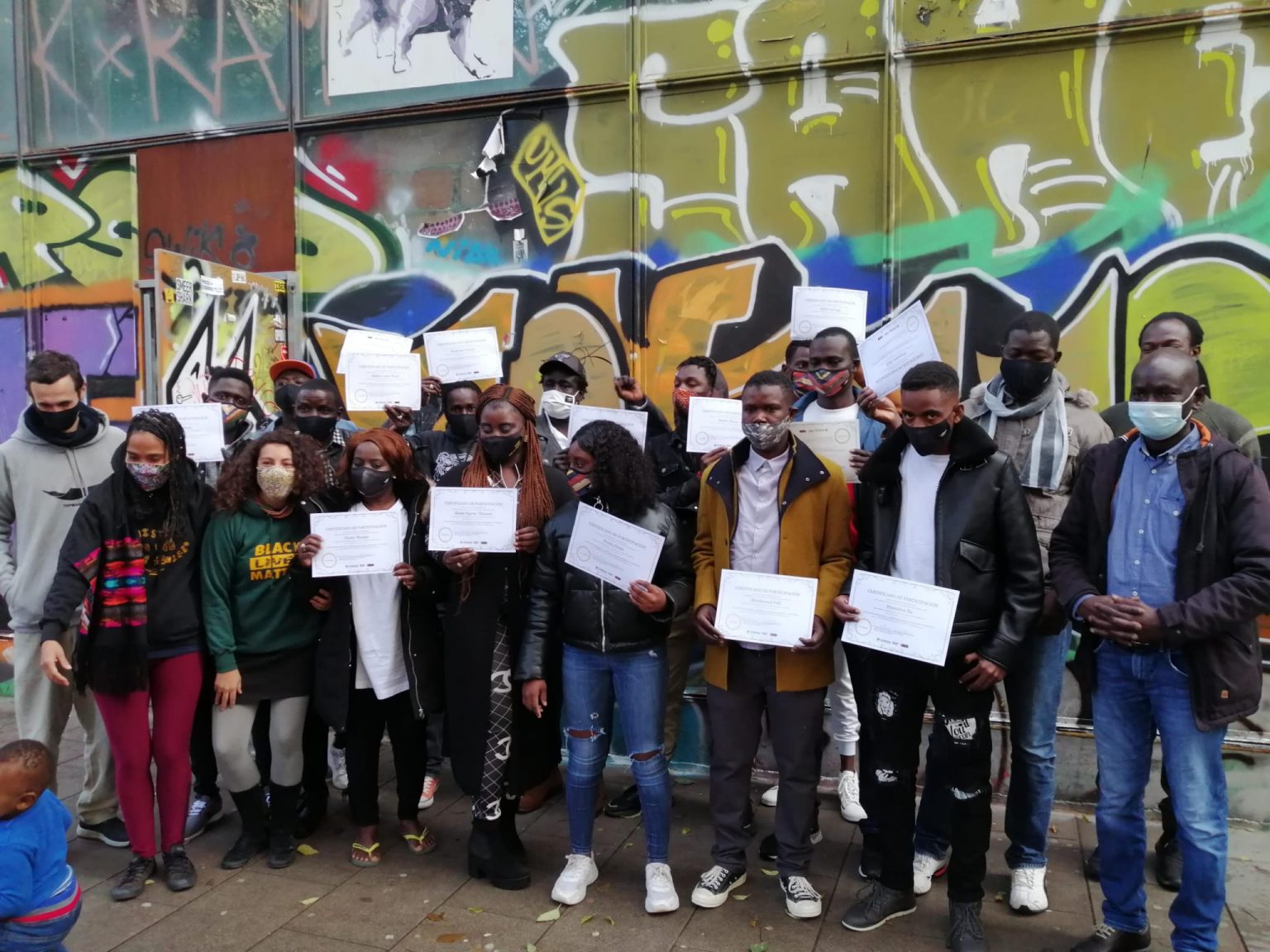 Grupo de participantes con sus certificados de participación en una formación de Migress