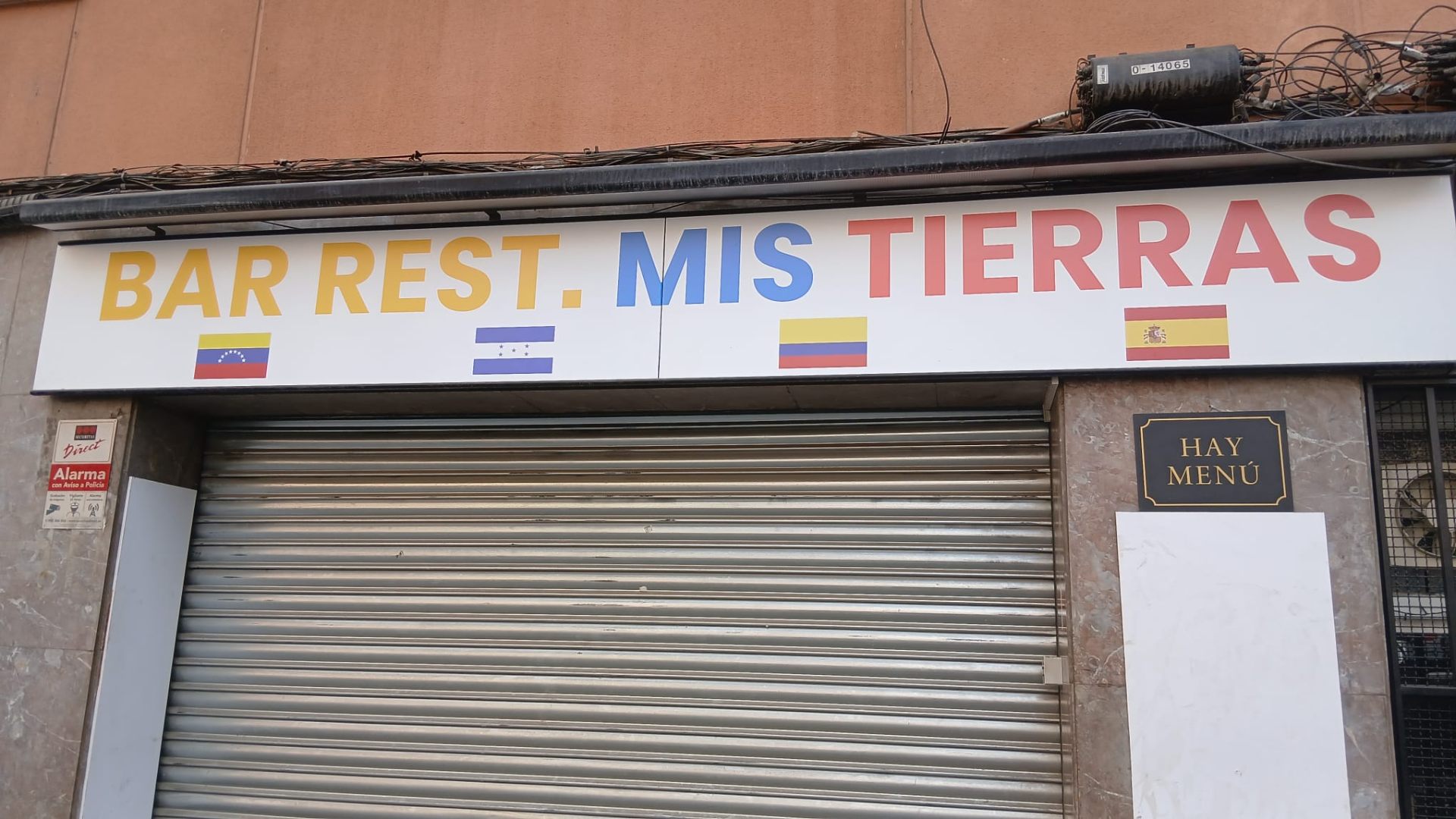 Antes: Rótulo de local con tipografías genéricas y banderas como único recurso visual.